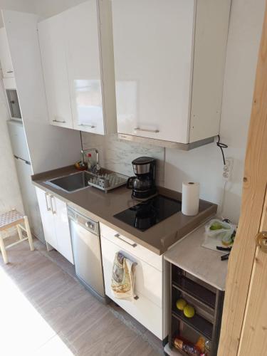 una cucina con mobili bianchi e un forno a piano cottura di La Casa del Patio ATQ ad Antequera