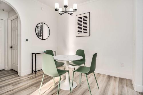 ein Esszimmer mit einem weißen Tisch und grünen Stühlen in der Unterkunft Boulevard Stays 1BR by Stadium Pool Parking Gym 01 in Glendale
