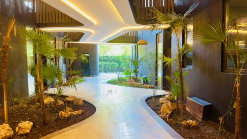 a hallway with palm trees in a building at Jungle Guardian - Rooftop Pool & Beach Club in Zona Hotelera Tulum in Tulum