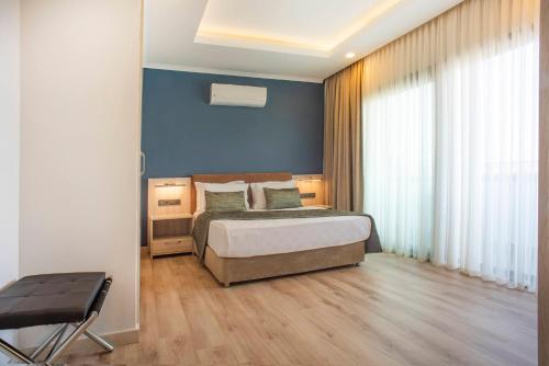 a bedroom with a bed and a blue wall at AMOSSİA Elite Boutique Hotel in Turunc