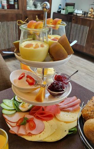 a three tiered plate of food on a table at Pension Miss Sophie in Kyritz