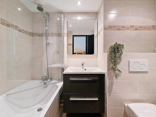 une salle de bain avec un lavabo, une baignoire et un miroir dans l'établissement **Studio rénové à Reberty, proche pistes, balcon, coin montagne et parking gratuit** - FR-1-344-859, aux Menuires