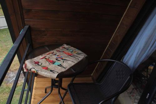 a table and a chair sitting on a porch at NitsHouse! in Tsemi