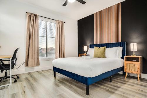 a bedroom with a bed and a desk and a window at Boulevard Stays 2BR by Stadium Pool Parking Gym 05 in Glendale