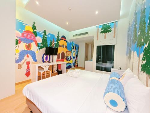 a bedroom with a white bed and a colorful wall at Beat Hotel Bangkok in Bangkok