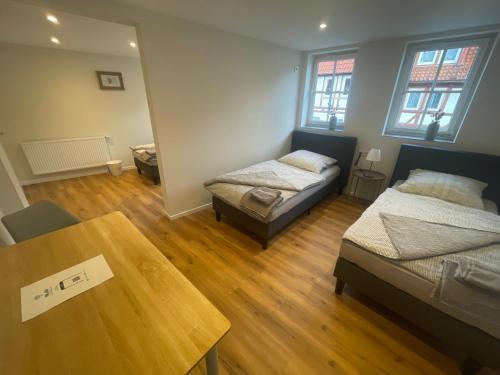 a room with two beds and a table in it at Gästezimmer alte Schneiderei in Duderstadt