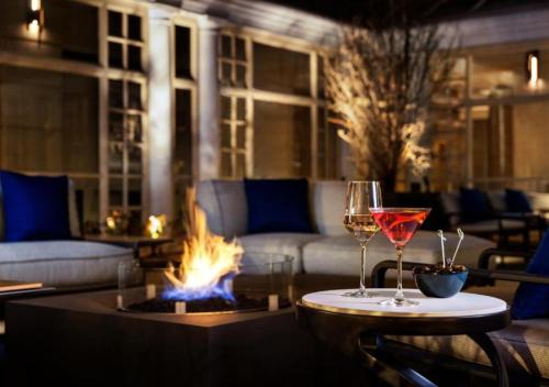 a living room with two wine glasses and a fire pit at Fairmont Washington DC Gold Experience in Washington
