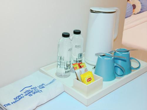 a shelf with two bottles and a blender on it at Beat Hotel Bangkok in Bangkok