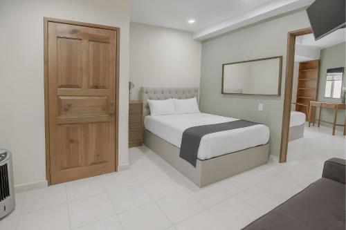 a bedroom with a bed and a bathroom with a mirror at Casa Santa Fe in Guanajuato