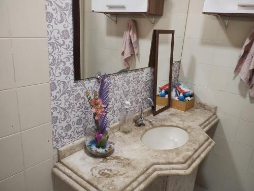 a bathroom with a sink and a mirror at Pousada Cantinho do Sossego in Várzea Grande