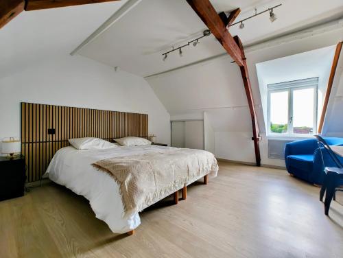 a bedroom with a large bed and a blue chair at Olhain - La Parenthèse in Fresnicourt-le-Dolmen