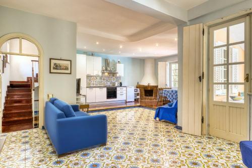 サンタ・フラーヴィアにあるVFH Villa Cala del Cuore con piscina, 50 m dal mareの青いソファとキッチンのあるリビングルーム