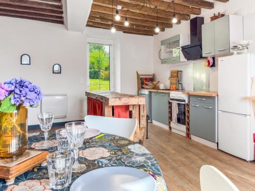 a kitchen and dining room with a table and chairs at La Maison du Lac in La Ferté-Macé