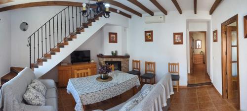 a living room with a table and a staircase at Casa Corredera in Cumbres Mayores