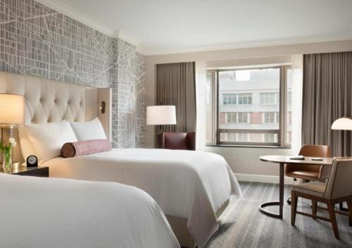 a hotel room with two beds and a desk and a window at Fairmont Washington DC Gold Experience in Washington