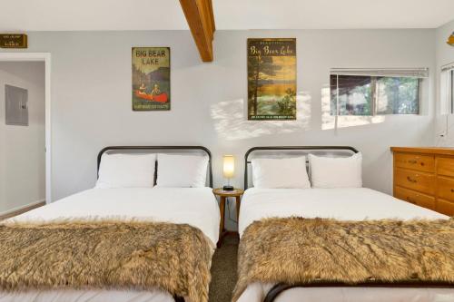 zwei Betten in einem Zimmer mit weißen Wänden in der Unterkunft Orchard Family Cabin #2560 in Big Bear Lake