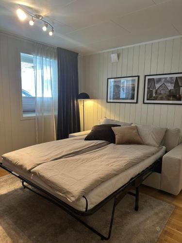 a bedroom with a large bed and a window at Leiligheten in Trondalen