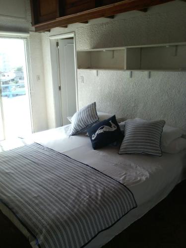 Una cama grande con almohadas encima. en Edificio Sarie Bay, en San Andrés