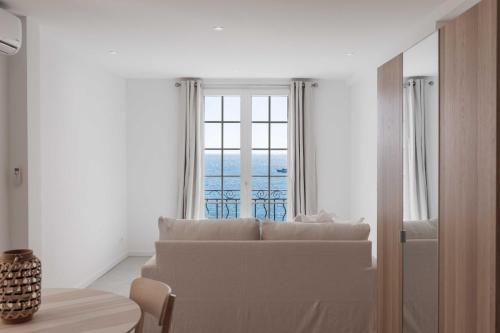アンティーブにあるCharming studio - 2P - Sea view - Antibesのソファと大きな窓のあるリビングルーム