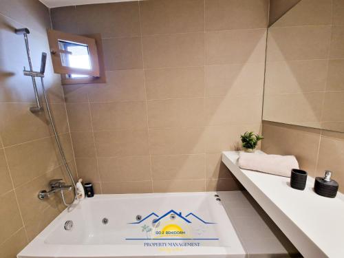 a bathroom with a tub with a sign on it at Intempo Golden Magic Sky Resort & Spa in Benidorm