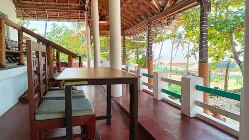 a table and chairs in a room with a fence at Marari Praise Beachfront Homestay in Mararikulam