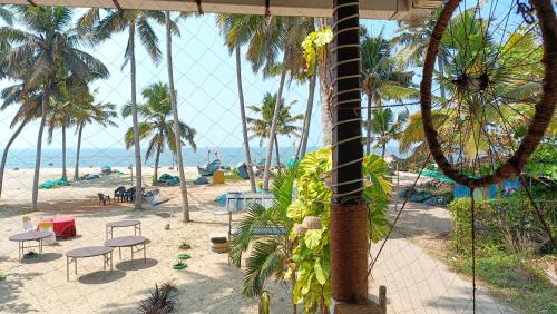 a view of a beach with chairs and palm trees at Marari Praise Beachfront Homestay in Mararikulam