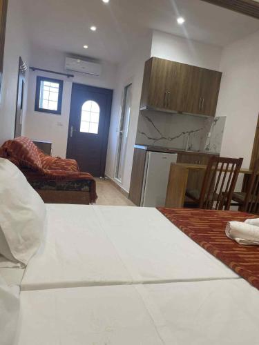 a kitchen and living room with a table and a couch at Guesthouse Joal in Përmet