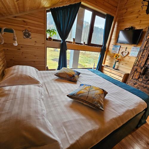 ein großes Bett mit zwei Kissen darauf in der Unterkunft La Căsuță in Vatra Dornei