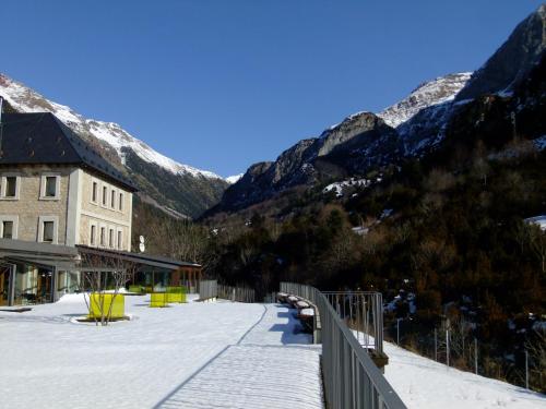 a building with a snow covered mountains in the background at Hotel Santa Cristina Petit Spa in Canfranc-Estación