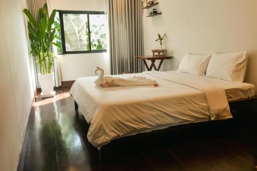 a bedroom with a large bed with a swan on it at Pomelo Outpost Cambodia ដំណាក់ភ្នំក្រោម in Phumĭ Rœssei Lŭk