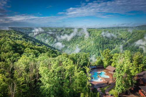 an aerial view of a resort in the forest with a bridge in the background at Adventures on the Gorge in Fayetteville