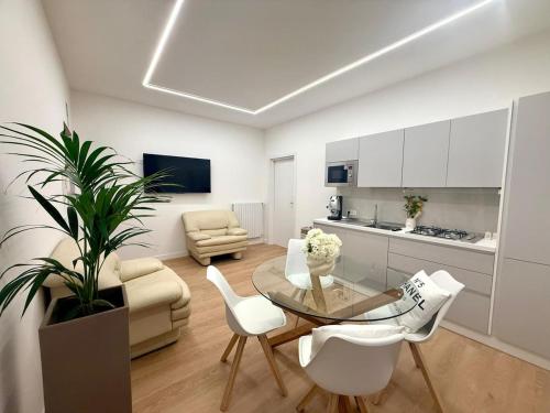 a living room with a glass table and white chairs at Flute 59 in Benevento