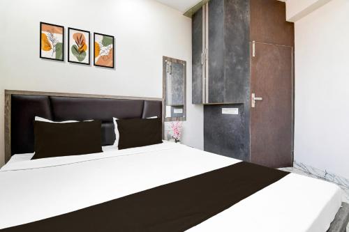 a bedroom with a large bed with a black headboard at Hotel O S. R. ROYALE in Kolkata