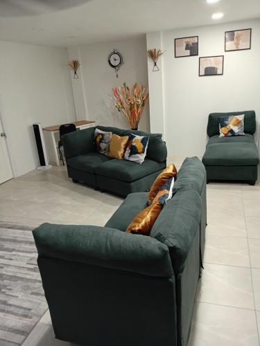 a living room with two green couches at Lawrence Legacy 2 in Saint Georgeʼs