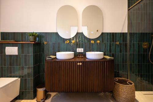 Un baño con dos lavabos y un espejo. en Casa La Brisa, en Arenas