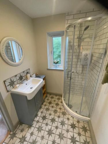 a bathroom with a sink and a shower at Lavender Lodge in Briston