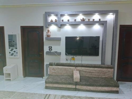 a living room with a flat screen tv on a wall at فندق ومطعم البرج in Fayoum Center