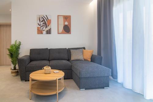 a living room with a couch and a table at Μilia Olive&Terra Apatments in Kynopiástai