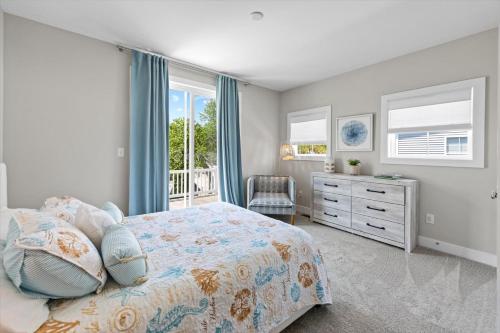 a bedroom with a bed and a dresser and windows at 5br Beauty Near Bethany-community Pool Linens in Ocean View