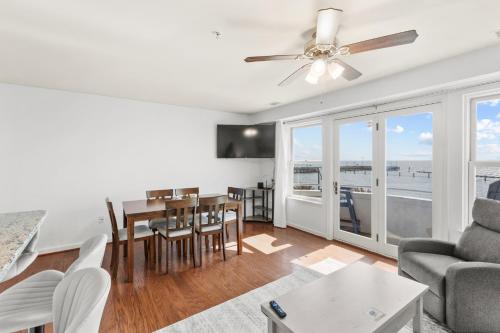 a living room with a ceiling fan and a dining room at Unbelievable Beach Views For 6 in North Beach