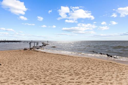 a sandy beach with a pier in the water at Unbelievable Beach Views For 6 in North Beach