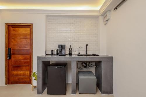 a kitchen with a table with a sink and a door at BOHO Boutique Bungalows in Baan Tai