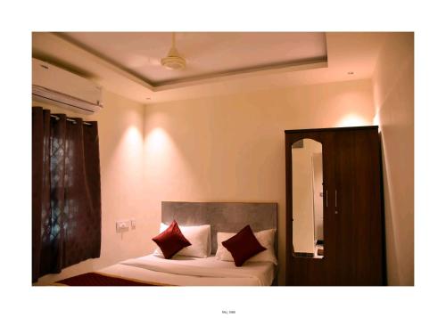 a bedroom with a bed with two red pillows at GK Luxury Stay in Tiruchchirāppalli