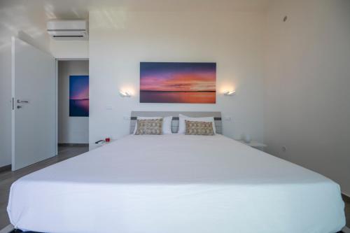 a bedroom with a large white bed in a room at Villa Plemmirio Sea View and pool in Plemmirio