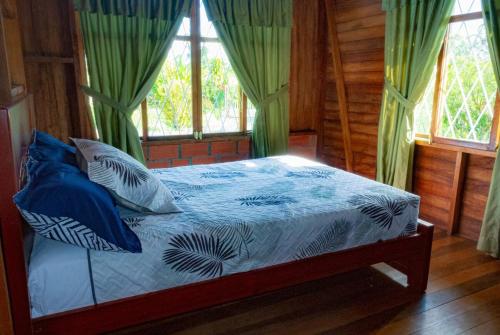 a bedroom with a bed with blue and white pillows at Family villa in Puyo in Tarqui