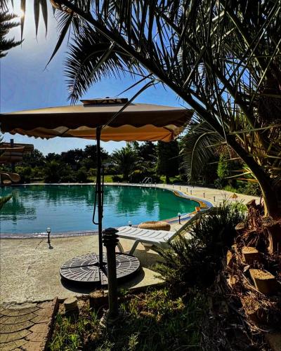 a table and an umbrella in front of a pool at Village Taste Guest House in Buzovna