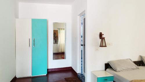 a room with a bed and a blue door at Marari Praise Beachfront Homestay in Mararikulam