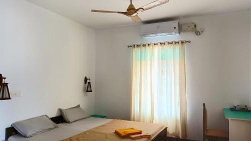 a bedroom with a bed and a ceiling fan at Marari Praise Beachfront Homestay in Mararikulam