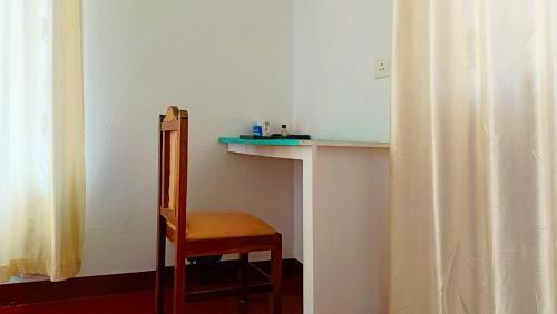 a chair in a room with a table and a shelf at Marari Praise Beachfront Homestay in Mararikulam