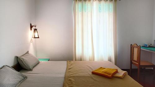 a bedroom with a bed and a chair and a window at Marari Praise Beachfront Homestay in Mararikulam